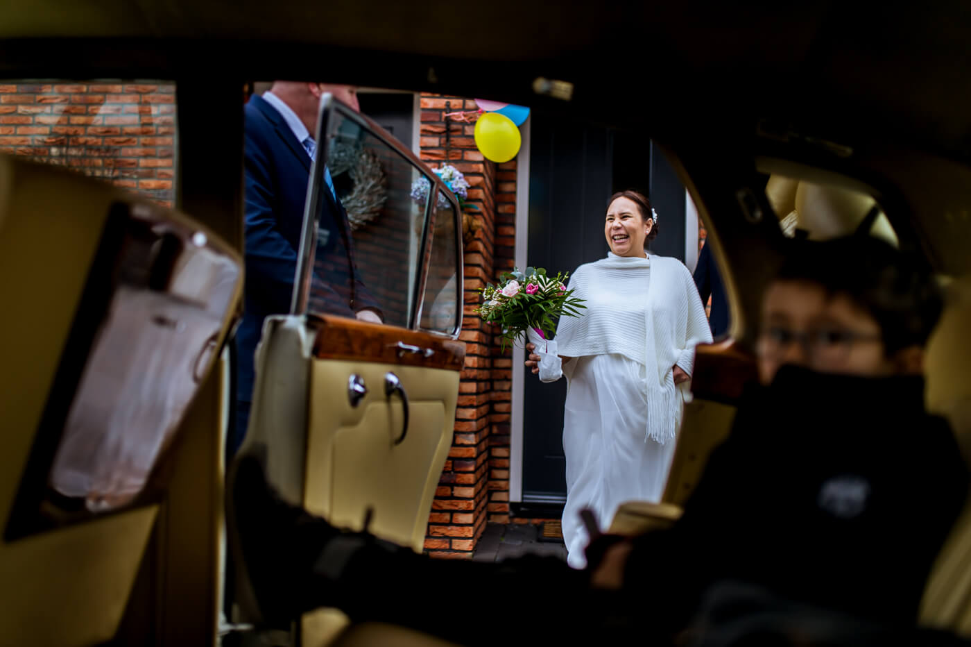 bruid stapt in de trouwauto
